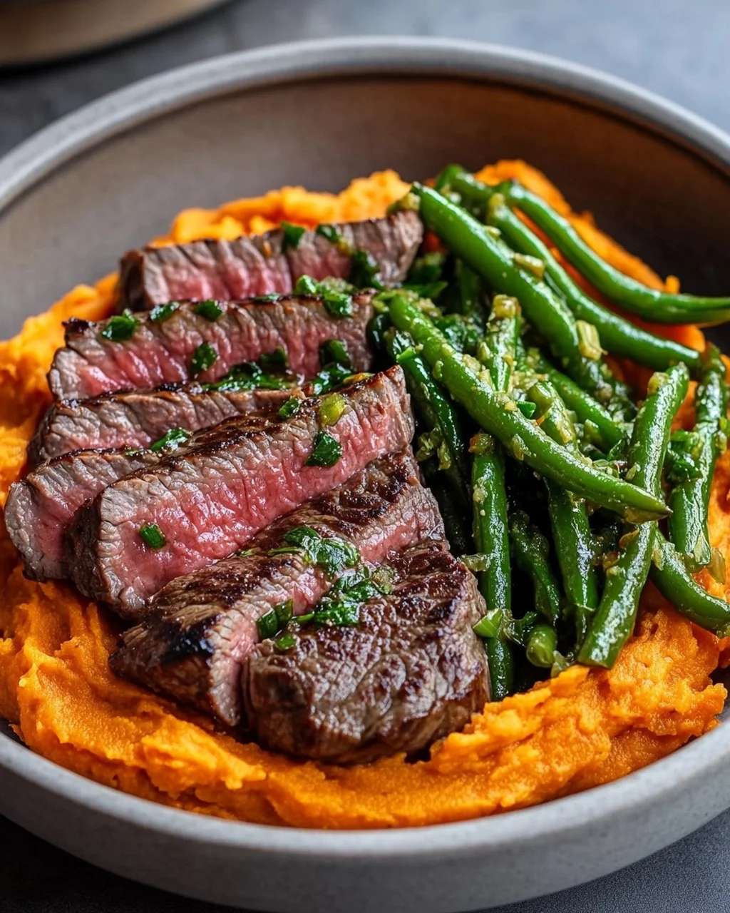 Leckere Steak Bowl mit Süßkartoffelpüree und grünen Bohnen